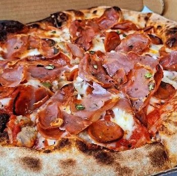Wood-fired pepperoni and salami pizza with a charred crust